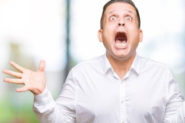 Orta yaş Arap zarif adam deli kutluyor arka plan izole ve başarı için kaldırdı kollarını açarak hayrete ve heyecanlı çığlık gözleri açık. Kazanan kavramı