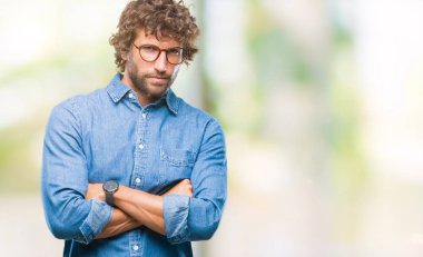 İzole arka plan şüpheci ve sinir, onaylamayan ifade yüz çapraz kolları üzerinde gözlük takan yakışıklı İspanyol modeli adam. Negatif kişi.