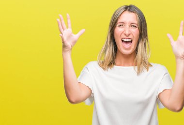 Genç güzel kadın deli kutluyor ve silah ile başarı için heyecanlı çığlık kaldırdı ve açık gözleri hayret izole arka plan yüzünden. Kazanan kavramı