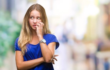 Genç güzel sarışın kadın yüzünden stresli ve gergin ile izole arka plan tırnak ısırma dudaklarından eller. Anksiyete sorunu.