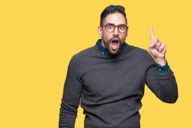 Başarılı fikirle izole arka plan işaret parmağı üzerinde gözlük takan yakışıklı delikanlı. Çıktıktan ve mutlu. Bir numara.