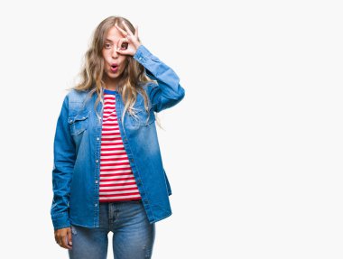 Güzel sarışın genç kadın Tamam jest sürpriz yüz, göz parmaklarının arasından seyir şok yapıyor izole arka plan üzerinde. İmansız ifade.