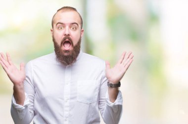 Genç beyaz hipster adam deli kutluyor arka plan izole ve başarı için kaldırdı kollarını açarak hayrete ve heyecanlı çığlık gözleri açık. Kazanan kavramı