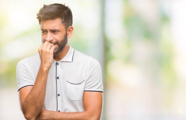 Yetişkin İspanyol adam stresli ve gergin ile izole arka plan üzerinde tırnak ısırma dudaklarından eller. Anksiyete sorunu.