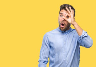 Sürpriz yüz, göz parmaklarının arasından seyir yakışıklı delikanlı ok jest yapıyor izole arka plan üzerinde şok. İmansız ifade.