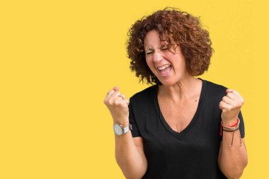 Gülümseyen ve başarı için çığlık güzel orta ager üst düzey kadın izole arka plan çok mutlu ve heyecanlı kaldırdı, silah ile kazanan jest yapıyor. Kutlama kavramı.