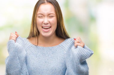 Zafer kutluyor gülümseyen izole arka kolları olan başarı için heyecan üzerinde kış kazak giyen genç güzel beyaz kadın kaldırdı. Kazanan kavramı.