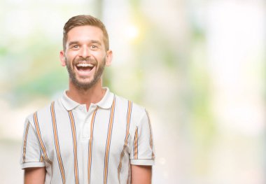 Yakışıklı delikanlı yüzünde mutlu ve güzel bir gülümseme ile izole arka plan üzerinde. Şanslı kişi.