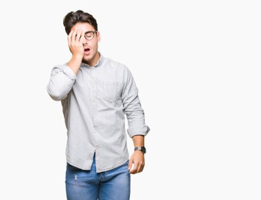 Yarım yüz, göz ve ağız el ile kapsayan yorgun esneme izole arka plan üzerinde gözlük takan yakışıklı delikanlı. Acı yüzü acıyor.