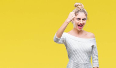 İzole arka plan öfkeli ve sinirli sinirli ve öfke ile bağırarak süre öfkeli yumruk yükselterek genç güzel sarışın ve mavi gözlü kadın. Öfke ve agresif kavramı.