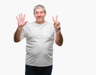 Üst düzey yakışıklı gösteren ve parmakları ile işaret izole arka plan üzerinde kendinden emin ve mutlu gülümseyerek süre yedi numara.