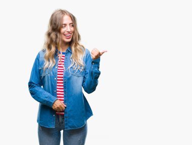 Seyir ve başparmak yanında yukarıyı mutlu yüz ile gülümseyen izole arka plan üzerinde sarışın güzel genç kadın.