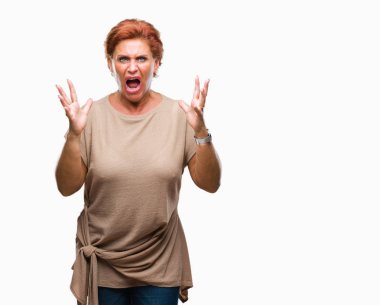 Atrractive üst düzey beyaz Kızıl saçlı kadın izole arka plan çılgın ve kızgın bağırarak ve agresif ifade ve silah kaldırdı bağırmaya. Hayal kırıklığı kavramı.