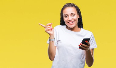 Arka plan el ve parmak ile tarafına işaret çok mutlu genç örgülü saç Afro-Amerikan kız üzerinde Smartphone kullanarak gösterilen izole
