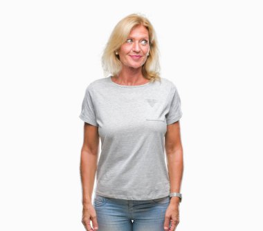 Orta yaş sarışın kadın görünümlü yan ve dik dik bakma uzağa düşünce gülümseyen izole arka plan üzerinde.