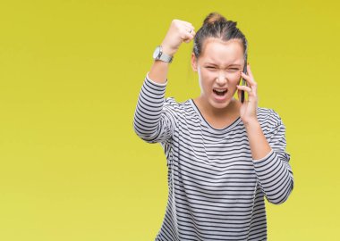 Genç güzel beyaz kadın smartphone üzerinde izole arka rahatsız ve öfke, çılgın ve yükseltilmiş eliyle diye bağıran ile sinirli bağırarak öfke kavramı söz