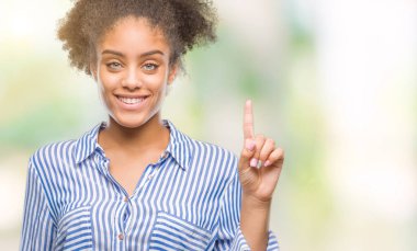 Genç afro Amerikalı kadın ve kendinden emin ve mutlu gülümseyerek süre parmak numaralı yukarıyı gösteren izole arka plan üzerinde.