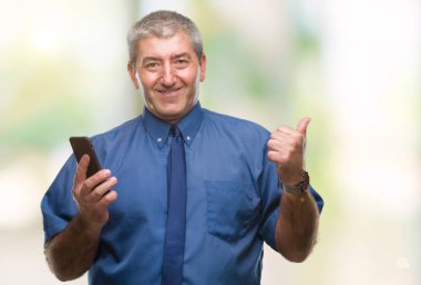 Yakışıklı komuta sizde manifatura işaret ve başparmak kadar mutlu yüz gülümseyen tarafı ile gösteren izole arka plan üzerinde Smartphone kullanarak ileti gönderme