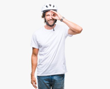 Yakışıklı İspanyol bisikletçi adamın gülümseyen, parmakları ile mutlu yüz üzerinden seyir göz el ile ok jest yapıyor izole arka plan üzerinde güvenlik kask giydiğini.