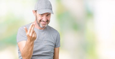 Beckoning gel burada mutlu ve gülümseyerek el davet ile jest arka plan üzerinde spor şapkası yakışıklı orta yaş ağarmış komuta sizde izole