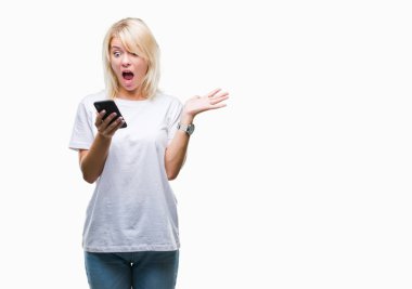 Smartphone üzerinde kocaman bir gülümseme ile çığlık zaferini kutluyor ve ellerini kaldırdı izole arka plan çok mutlu ve heyecanlı, kazanan ifade kullanan genç güzel sarışın kadın