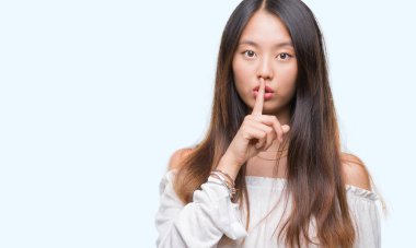 Dudaklarında parmak ile sessiz olmanı izole arka plan üzerinde Genç Asyalı kadın. Sessizlik ve gizli kavramı.