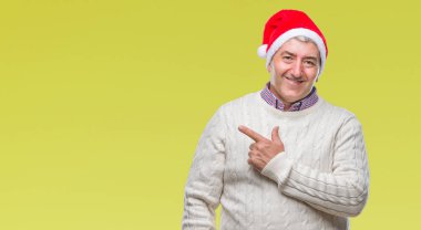 Üst düzey yakışıklı Noel şapka izole arka neşeli bir gülümseme ile el ve parmak kadar kameraya bakarak yüzündeki mutlu ve doğal ifade ile yan ile işaret yüz üzerinden.