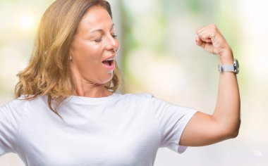 Orta yaş üst düzey İspanyol kadın kol kasları gururlu gülümseyen gösterilen izole arka plan yüzünden. Fitness kavramı.