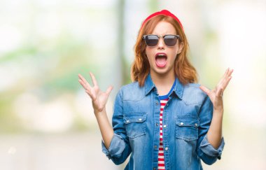 Genç güzel kadın çılgın ve kızgın bağırarak ve agresif ifade ve silah kaldırdı bağırmaya güneş gözlüğü takıyor izole arka plan yüzünden. Hayal kırıklığı kavramı.