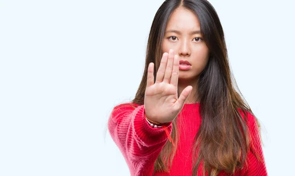 年轻的亚洲妇女穿着冬季毛衣在孤立的背景下做停止唱歌与手掌的手 脸上带有否定和严肃手势的警告表达式 — 图库照片