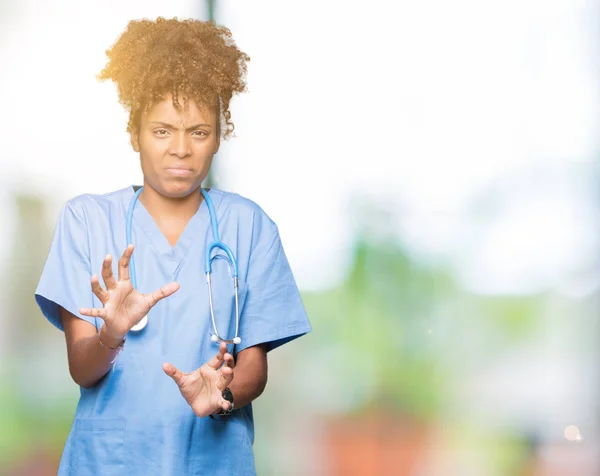 Young african american doctor woman over isolated background disgusted expression, displeased and fearful doing disgust face because aversion reaction. With hands raised. Annoying concept.