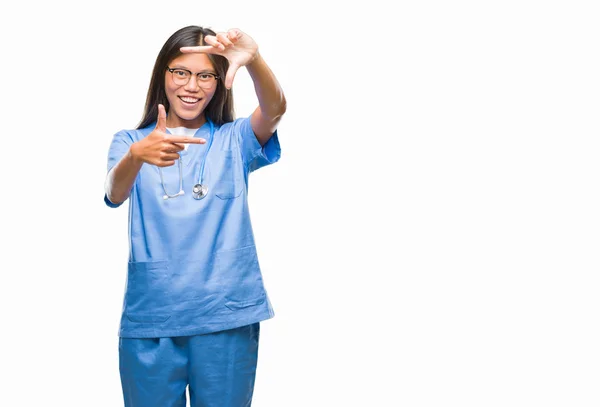 笑顔の幸せそうな顔で指と手作りフレーム分離の背景の上の若いアジア医師女性 創造性と写真のコンセプト — ストック写真