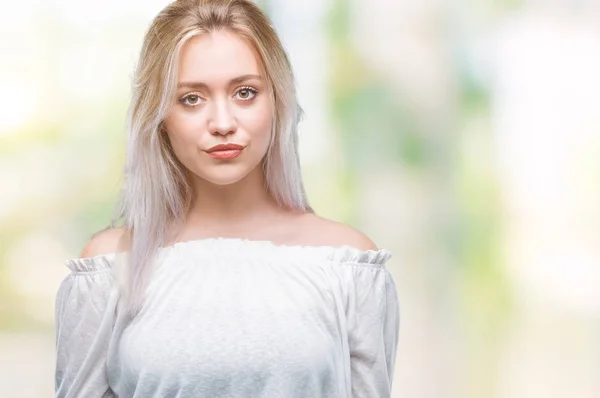 Young blonde woman over isolated background with serious expression on face. Simple and natural looking at the camera.