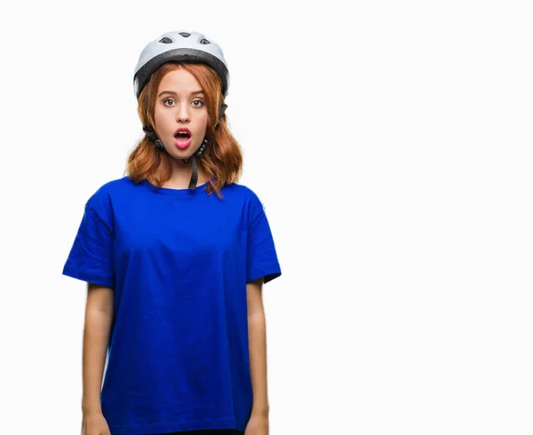 年轻美丽的女人穿着自行车头盔在孤立的背景下害怕和震惊与惊喜的表情 恐惧和兴奋的脸 — 图库照片