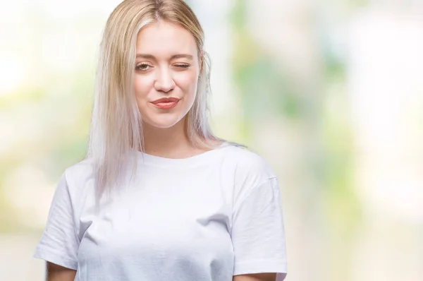 年轻的金发女人在孤立的背景下眨眼看着相机与性感的表情 开朗和快乐的脸 — 图库照片