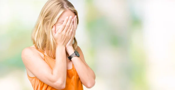 上のオレンジ色のシャツを着ての美しい若い女性は泣きながら手で顔を覆っている悲しそうな表情と背景を分離しました うつ病の概念 — ストック写真