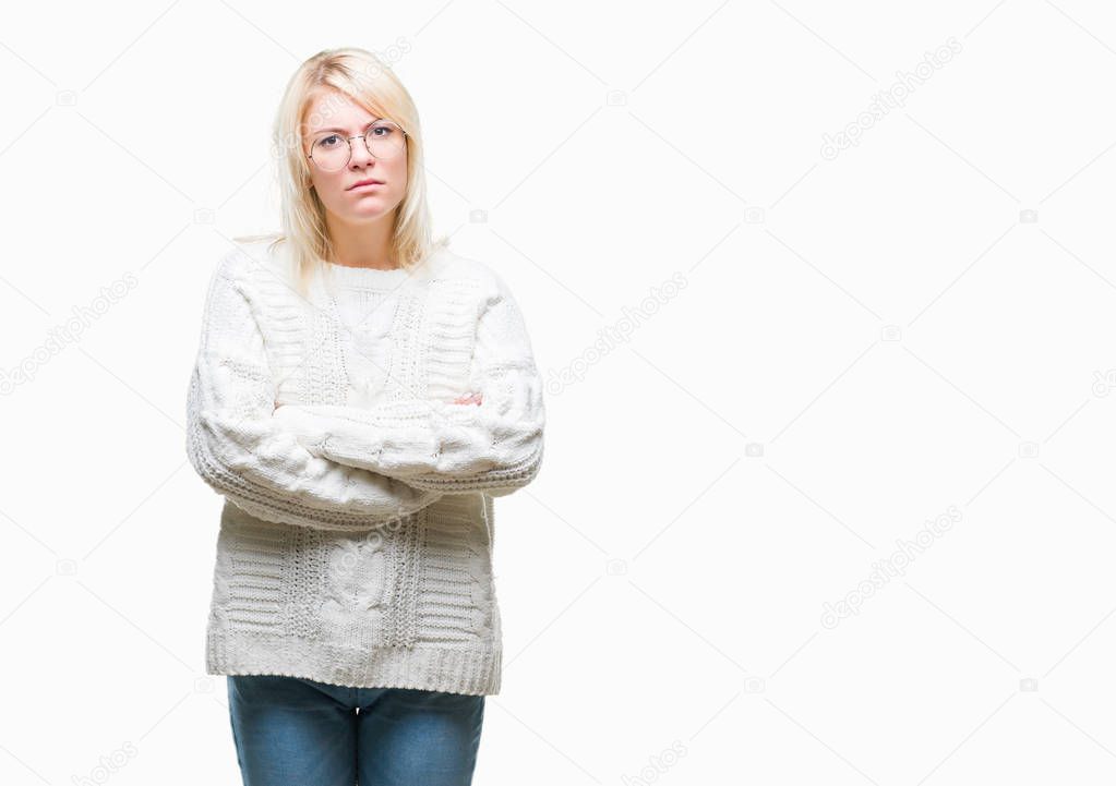 Young beautiful blonde woman wearing winter sweater and glasses over isolated background skeptic and nervous, disapproving expression on face with crossed arms. Negative person.