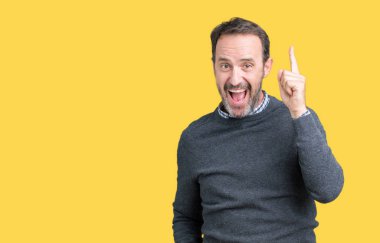 Yakışıklı orta yaş komuta sizde başarılı fikirle izole arka plan üzerinde işaret parmağı bir kazak giyiyor. Çıktıktan ve mutlu. Bir numara.