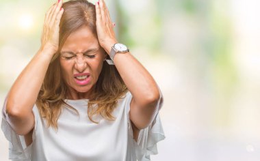 İspanyol kadın kıdemli orta yaş çünkü umutsuz ve stresli baş ağrısı acı izole arka plan üzerinde ağrı ve migren. Ellerini kafasına.