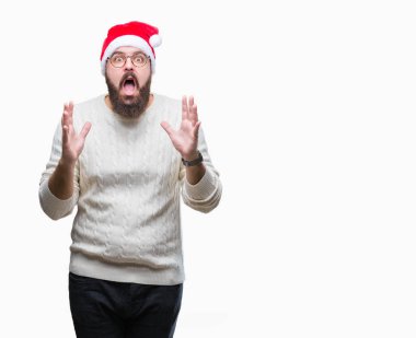 Üzerinde Noel şapka ve gözlük takan Genç beyaz adam arka plan deli izole ve deli bağırarak ve agresif ifade ve silah kaldırdı bağırıyor. Hayal kırıklığı kavramı.