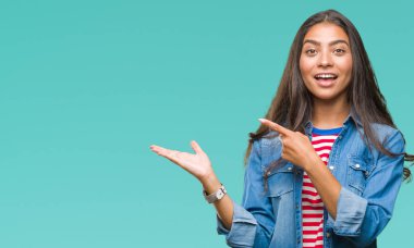 Genç güzel Arap kadın üzerinden hayran ve el ile sunulması ve parmak ile işaret ederken kameraya gülümseyen izole arka plan.