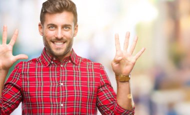 Yakışıklı delikanlı gösterilen ve parmakları ile işaret izole arka plan üzerinde numara 9 kendinden emin ve mutlu gülümseyerek süre.