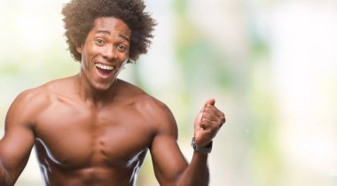 Afro Amerikalı gömleksiz adam çıplak vücut izole arka plan kutlama üzerinde gösterilen şaşırttı ve başarı için kaldırdı kollarını açarak hayret ve gözleri açık. Kazanan kavramı.