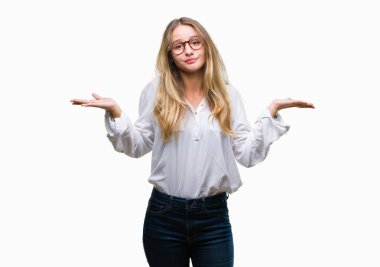 Üzerinde gözlük takan genç güzel sarışın iş kadını arka plan clueless ve şaşkın bir ifadeyle kollar ve eller kaldırdı izole. Şüphe kavramı.