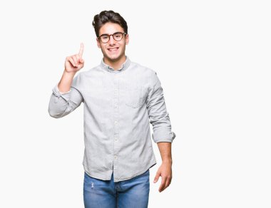 Ve kendinden emin ve mutlu gülümseyerek süre parmak numaralı yukarıyı gösteren izole arka plan üzerinde gözlük takan genç yakışıklı adam.