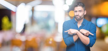 Yakışıklı delikanlı izole arka plan üzerinde işaretleme için her iki parmak, farklı yönde ile katılmıyorum