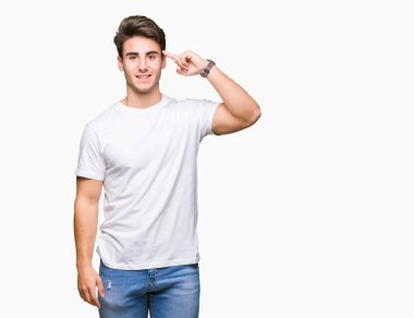 Beyaz t-shirt üzerinde izole giyen genç yakışıklı adam arka plan bir parmak, harika bir fikir ya da düşünce, iyi hafıza ile baş gösteren gülen