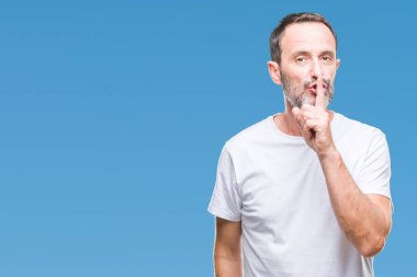 Dudaklarında parmak ile sessiz olmanı izole arka plan üzerinde beyaz t-shirt giyen orta yaş ağarmış komuta sizde. Sessizlik ve gizli kavramı.