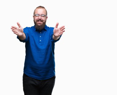 Sarılmak için kollarını açarak gülümseyerek kameraya bakarak izole arka plan üzerinde gözlük takan Genç beyaz hipster adam. Neşeli ifade kucaklayan mutluluk.