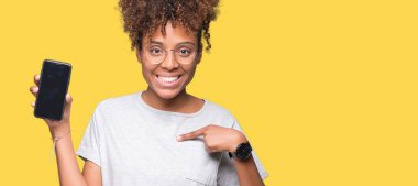 Genç Afro-Amerikan kadın gösteren smartphone ekran kendisi için sürpriz yüz işaret parmağı ile izole arka plan üzerinde